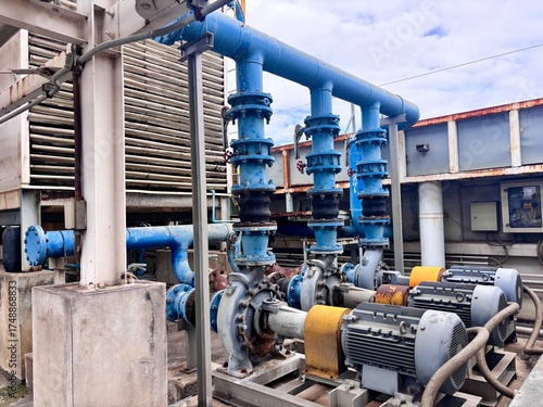 Industrial water pump system with connected pipelines and electric motors, used for fluid distribution and cooling in a factory or large facility.