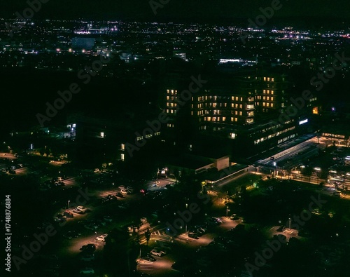 Night Cityscape with Illuminated Buildings and Parking Lot
