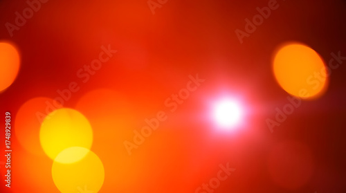 Abstract festive background with warm hued blurred bokeh spots and a glowing bright point of light. Ideal for holiday, celebration, or abstract design projects.