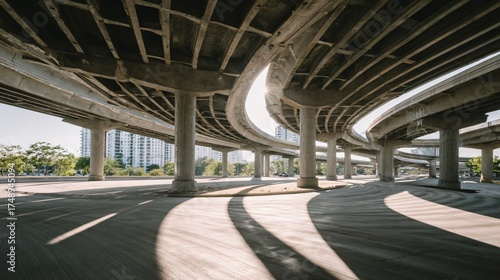 Modern concrete freeway overpass with sunlight creates dynamic urban atmosphere, ideal for transportation and infrastructure themes or city planning visuals
