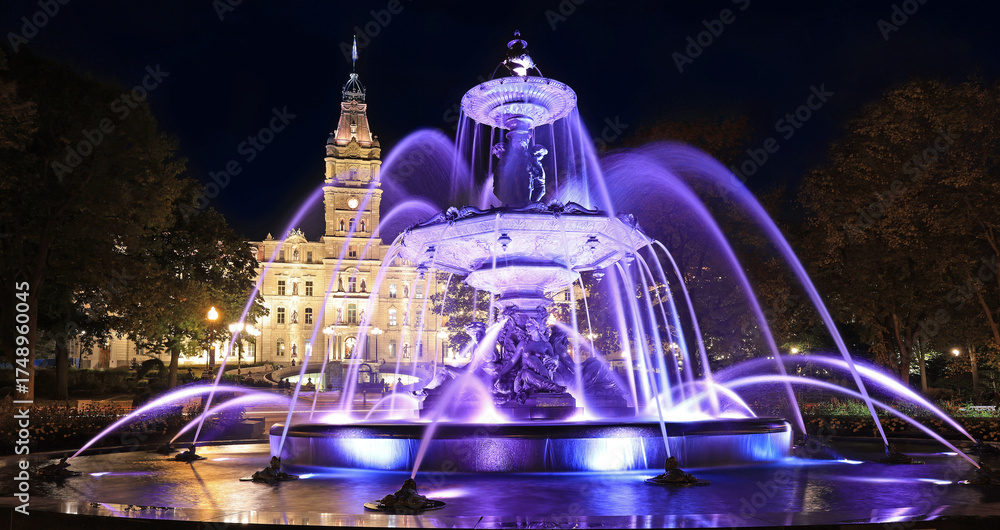 Naklejka premium Quebec City Parliament illuminated at night with The Fontaine de Tourny on the foreground, Canada