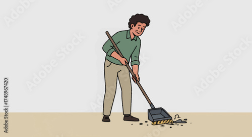 A smiling man in a green shirt and khaki pants sweeps dirt into a dustpan with a broom.