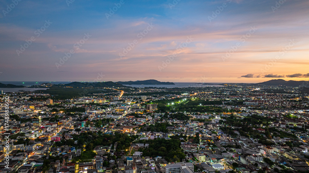 Fototapeta premium Aerial view of Khao Rang Viewpoint at dusk an important landmark in Phuket Town Khao Rang Viewpoint offers a panoramic view and the twinkling lights of Phuket Town at night, which are beautiful.