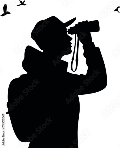 Silhouette of a person birdwatching with binoculars in nature