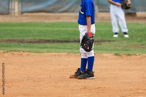 Принти на полотні A young boy playing baseball stands on the field