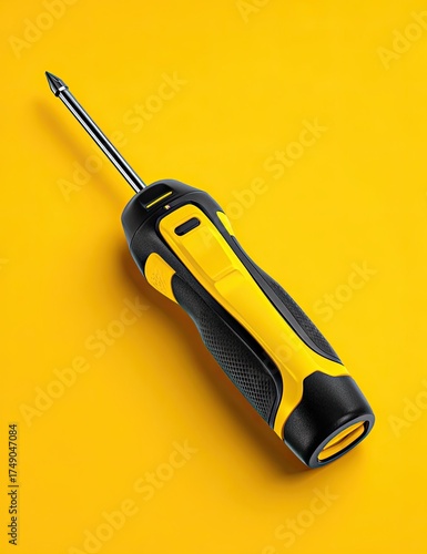 A yellow and black cordless screwdriver, angled on a bright yellow background