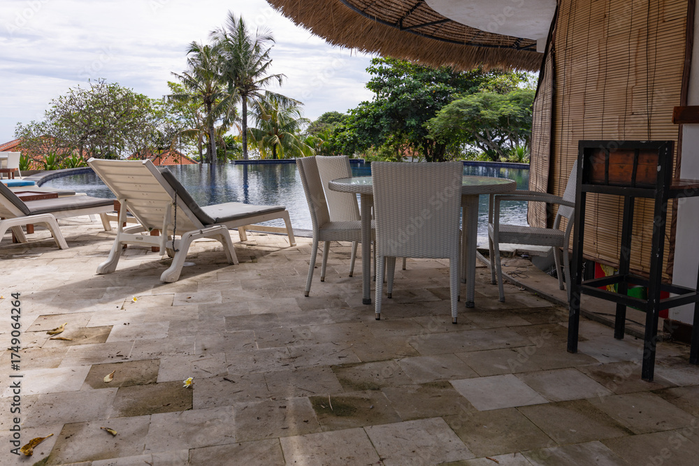 Fototapeta premium Poolside area with a white umbrella and chairs