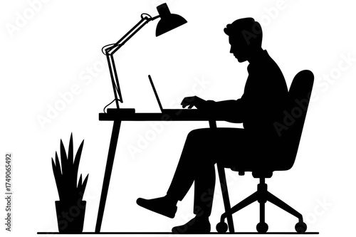 Silhouette of a person working on a laptop at a desk with a lamp and a potted plant nearby