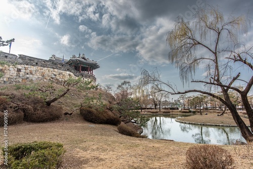 Captured this serene view of Hwaseong Fortress' Banghwasuryujeong in March. The calm pond and traditional architecture under a cloudy sky are just stunning. A perfect spring moment!