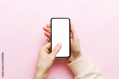 Top view of woman hands holding smart phone with blank copy space screen for your text message or information content. woman hand using phone white screen on top view