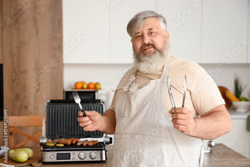 Mature man with tong, fork,...