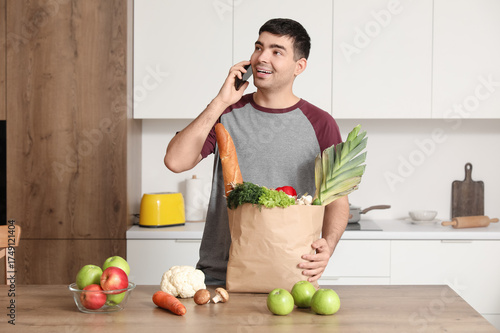 Young man with grocery bag ...