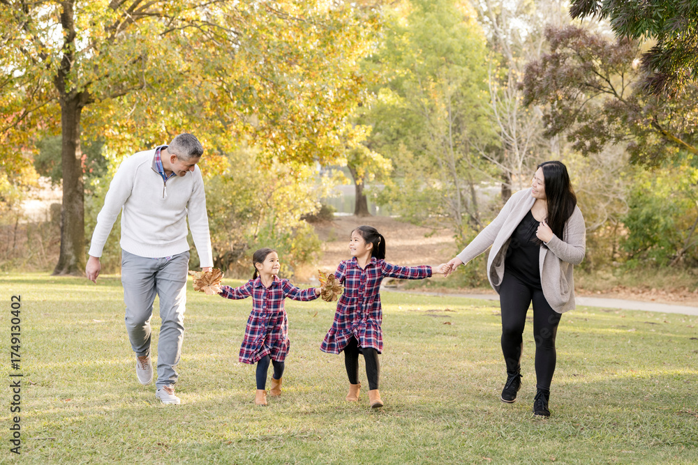 Obraz premium Family laughing and walking together on a sunny fall day
