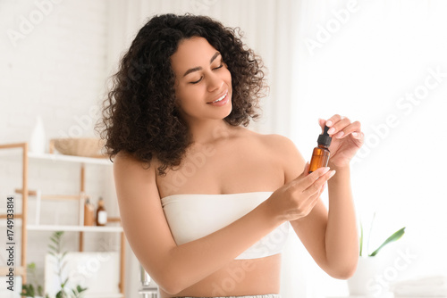 Skincare and beauty routine, young woman applying organic facial serum for he...