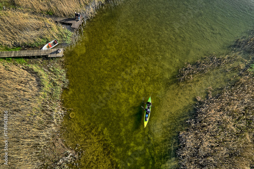 Fototapeta Naklejka Na Ścianę i Meble -  Drone top-down shot of kayak among reeds in Masurian lake waters, summer landscape