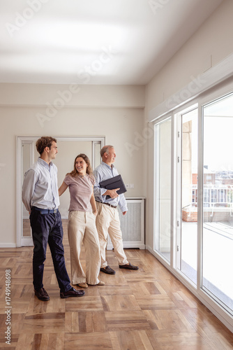 Realtor agent showing new empty house to young couple