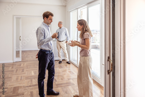 Young couple disagreeing with real estate agent during house viewing