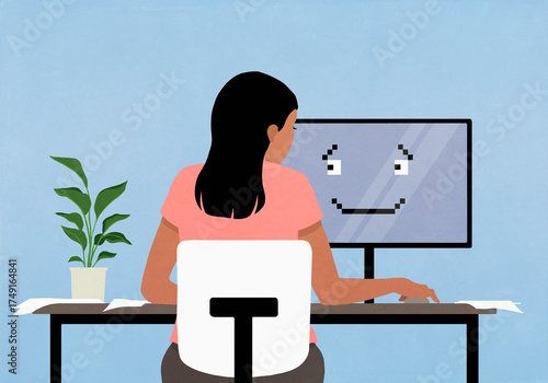Woman working at computer with smiley face on screen
