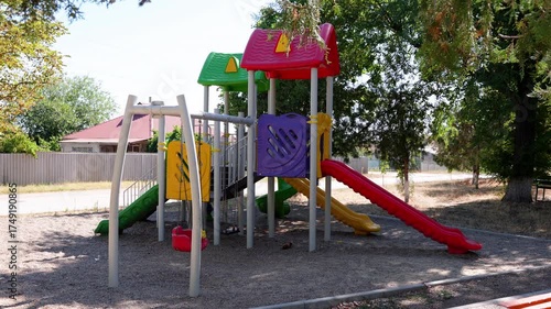 Wallpaper Mural Colorful playground structure featuring slides and climbing frames, showcasing vibrant play equipment in a sunny outdoor setting with surrounding trees and open space Torontodigital.ca