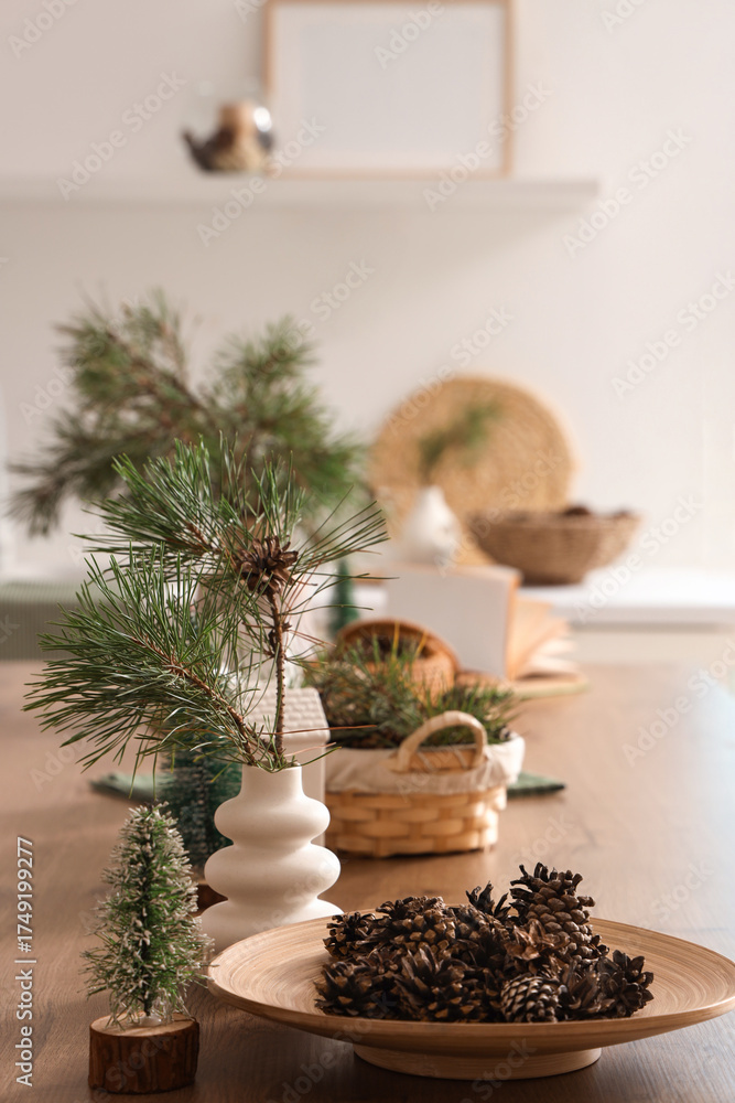 Fototapeta premium Coniferous cones with pine tree branches on table in kitchen