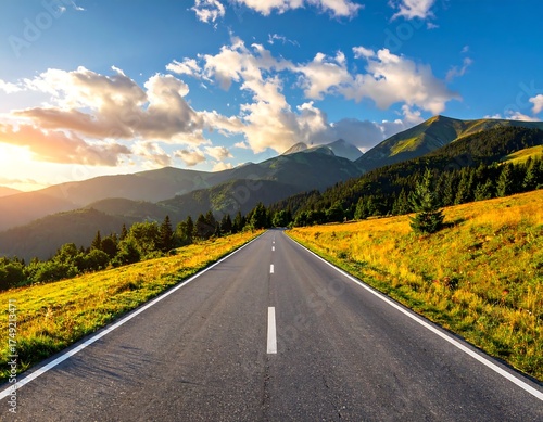 A long, straight road stretches towards distant mountains under a sky filled with clouds, bathed in golden sunlight