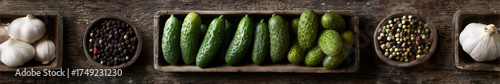 A flat-lay of pickling ingredients (cucumbers, garlic, dill, spices) on a wooden cutting board,  top-down view.