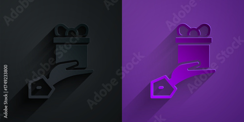 Paper cut Give gift icon isolated on black on purple background. Gift in hand. The concept of giving and receiving a gift. Paper art style. Vector