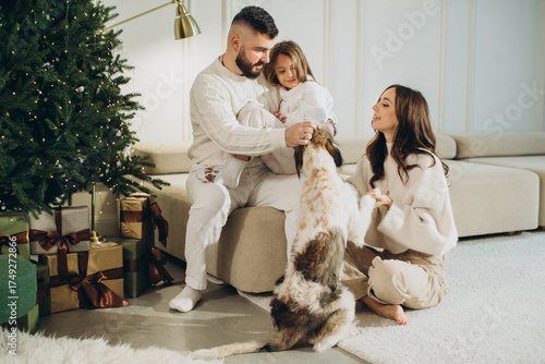 Family enjoying christmas with pet dog at home
