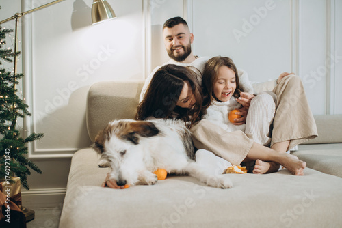 Happy family with pet dog celebrating christmas at home