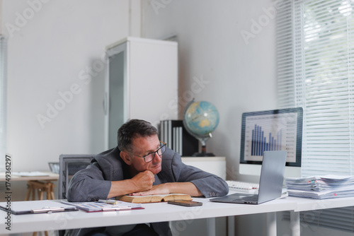 Tableau sur toile Tired man leaning on desk in office