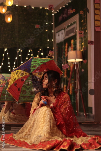 Nepali Indian girl in red and yellow traditional dress holding colorful umbrella during festive celebration