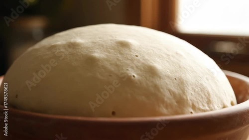 Close up of risen dough in a brown bowl. Homemade bread preparation concept. Baking process. Cooking footage for video.