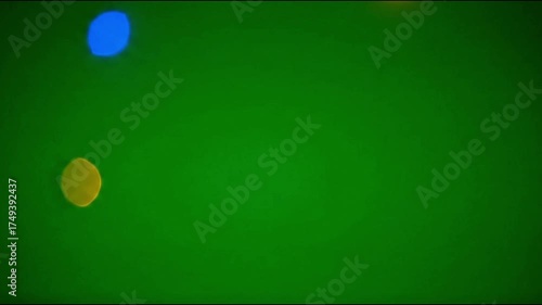 Colorful bokeh lights appearing and fading repeatedly, isolated on a green screen background.