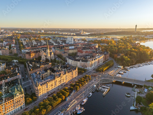Aerial view of golden light bathing the cityscape, highlighting the spires of churches and the winding waterways, Stockholm, Stockholm County, Sweden.