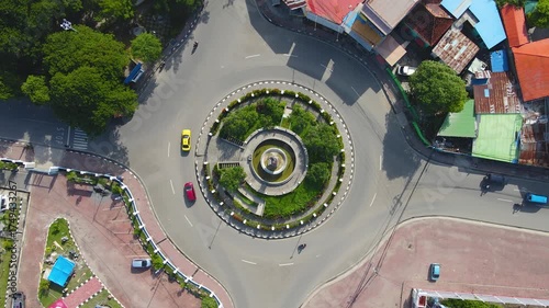 A perfect top-down aerial view of the President Francisco Xavier do Amaral roundabout in Dili, Timor-Leste. This bird's-eye perspective captures the perfect circular pattern of traffic.