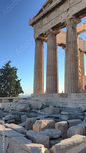 Side perspective of the Parthenon temple on the Acropolis in Athens, Greece, captured during golden hour. ancient marble columns and the harmony of classical architecture against the blue sky