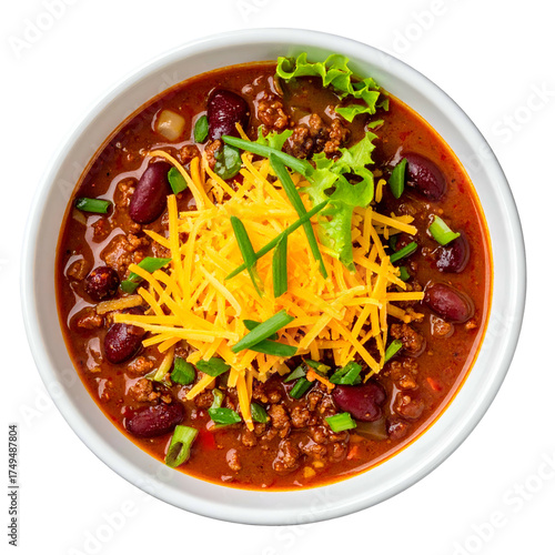 Overhead shot of chili in a white bowl, topped with cheese, greens, and chives