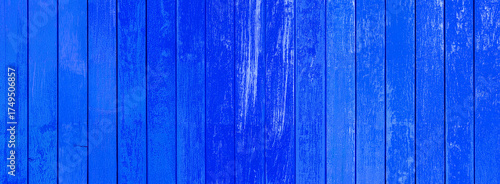 Bright blue painted wooden planks showing distressed weathered paint and natural wood grain texture for vintage or rustic background use.