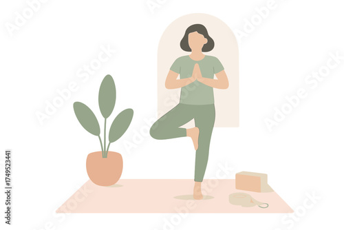 Woman practicing Vrksasana Tree Pose on a yoga mat next to a houseplant and accessories