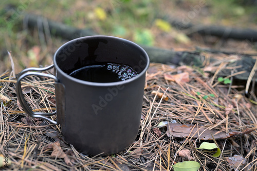 Metal Mug with Coffee on Forest Ground