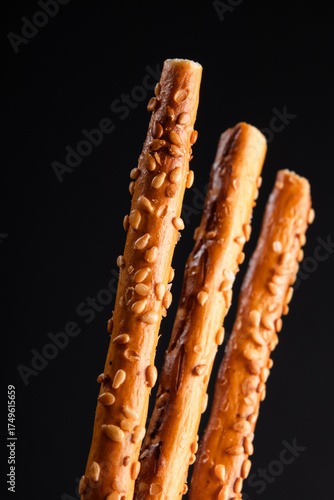 salted breadsticks with sesame seeds, close arrangement, baked snack