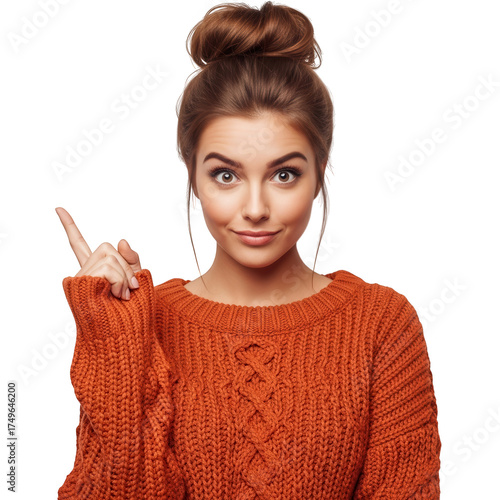 Young woman gesturing pointing up with orange sweater and bun hairstyle isolated on white background