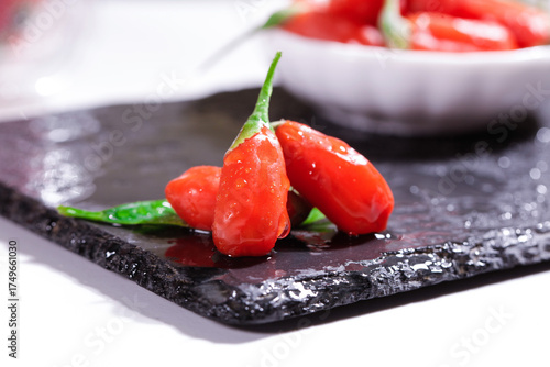Quadro em tela Fresh Red Ningxia Wolfberries Goji Berries on Black Slate Stone with Water Dropl