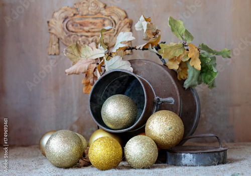 A metal pot with  Christmas balls and dry oak branch