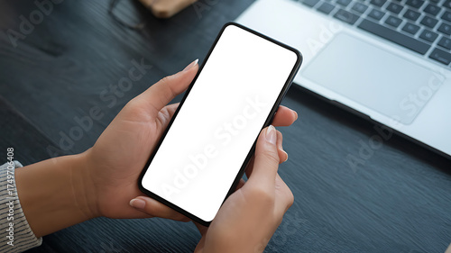 Hand holding a sleek mobile device displaying a blank screen, modern technology usage.