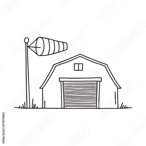 A windsock close to a hangar with its doors slightly open