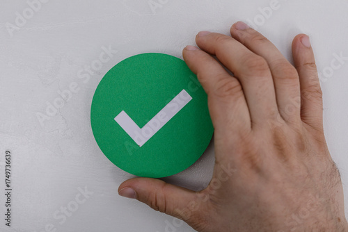 Hand touching a green check...