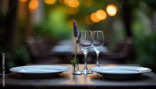 Outdoor Bistro Table, Evening Ambiance, City View A medium shot of a charming outdoor bistro table for two. Set with simple white plates, delicate wine glasses, and a small vase with a single lavender