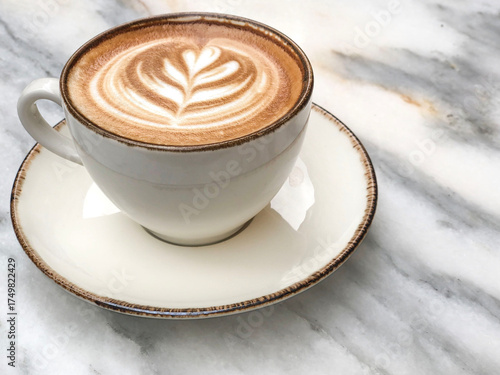side view coffee with latte art on marble table in cafe