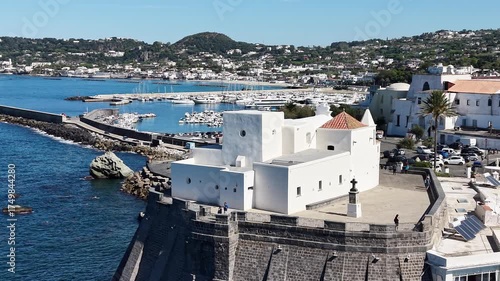 Beautiful white church Santa Maria del Soccorso
in Forio of Ischia island in Italy coastal drone shot with deep blue sea waves, cliffs and sunny weather. 